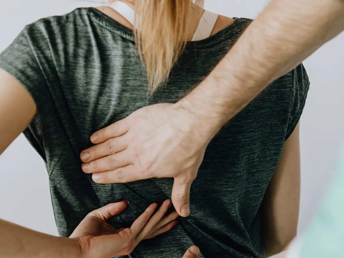 Hands checking a patient's upper and lower back