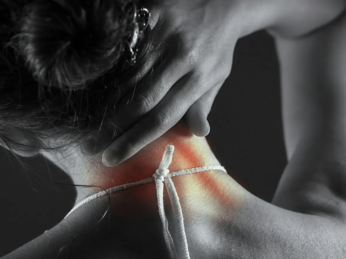Person holding a sore neck